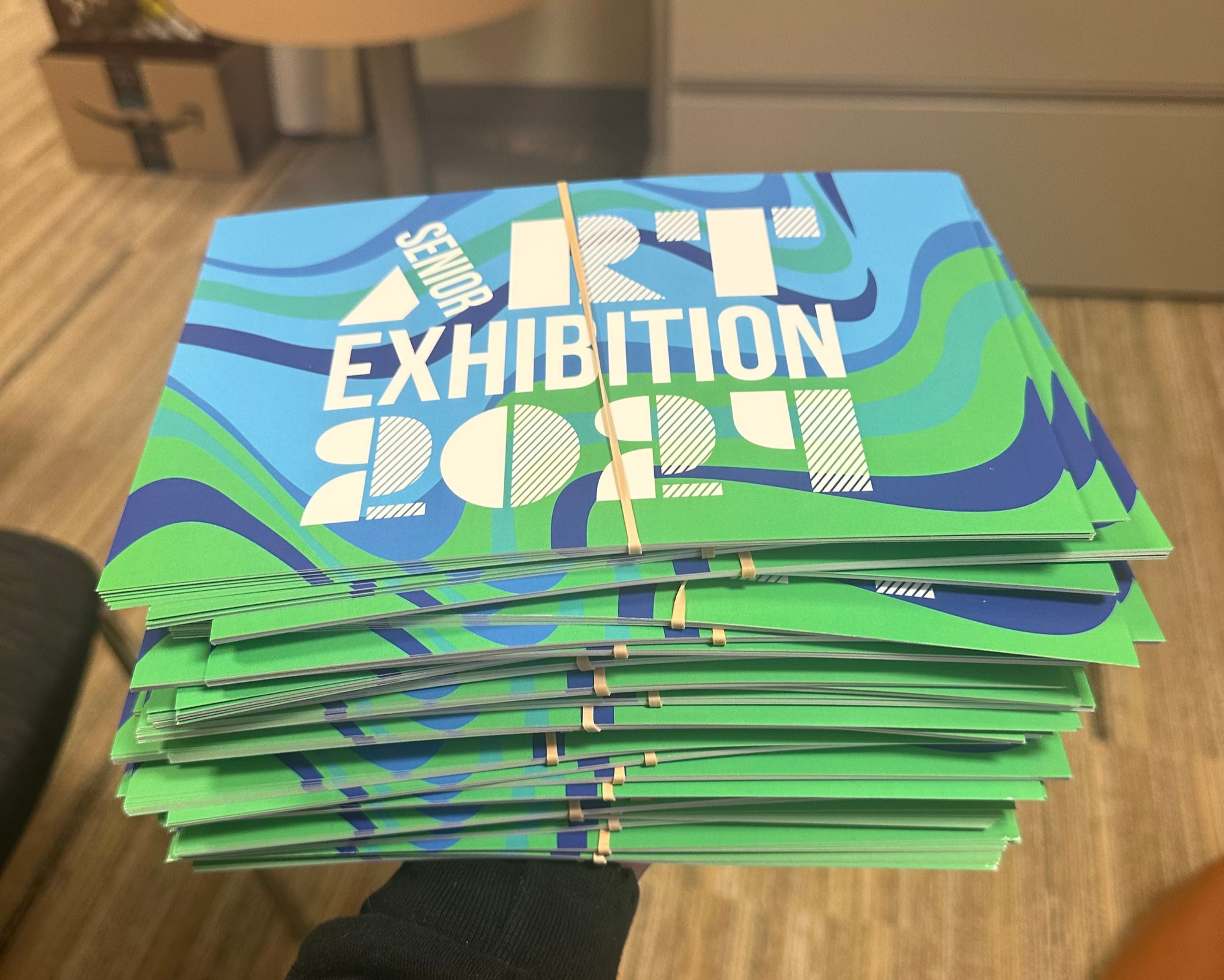 A large stack of promotional postcards prepared to be distributed to students.