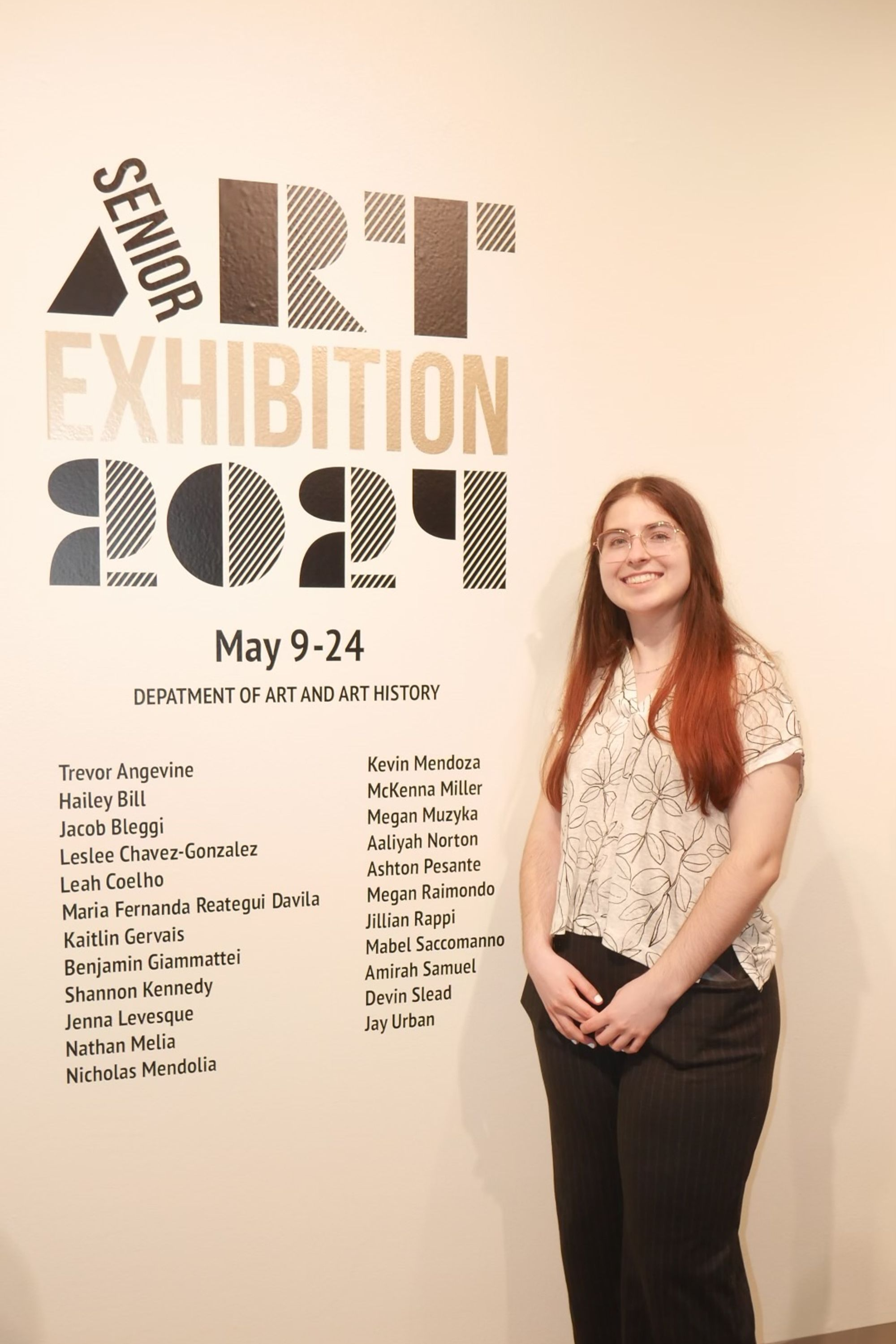 Designer displayed alongside branded typography vinyl sticker on the exhibition wall.